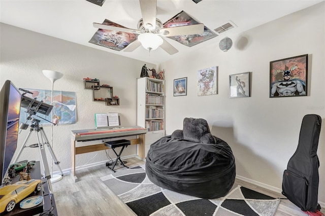 home office featuring visible vents, baseboards, wood finished floors, and a ceiling fan