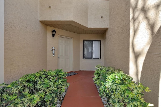 view of exterior entry with stucco siding