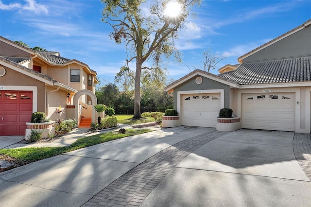 view of home's exterior featuring concrete driveway, a garage, a tile roof, and stucco siding