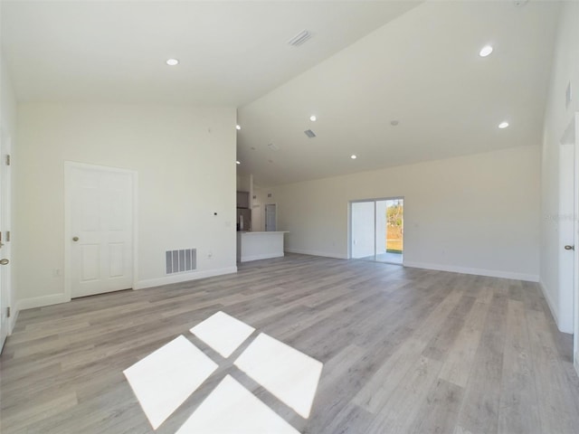 unfurnished living room featuring light wood-type flooring, visible vents, baseboards, and recessed lighting