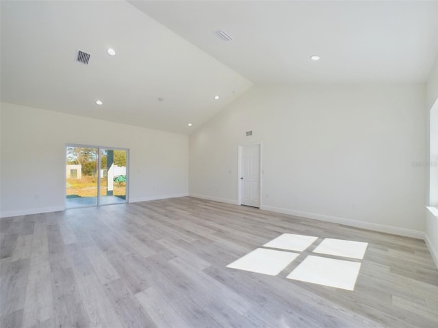 spare room featuring high vaulted ceiling, light wood-type flooring, visible vents, and baseboards