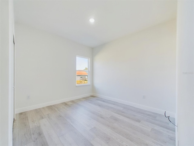 spare room featuring recessed lighting, light wood-style flooring, and baseboards