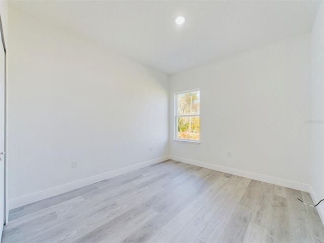 empty room with light wood-type flooring, baseboards, and recessed lighting