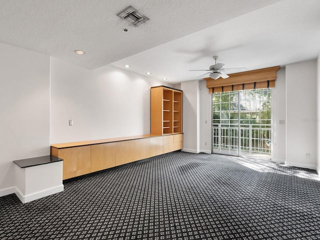 carpeted spare room with visible vents, a textured ceiling, and baseboards