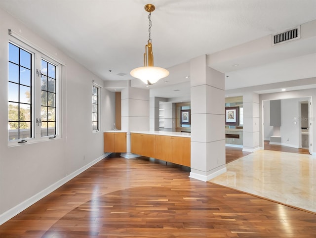 interior space featuring a sink, baseboards, visible vents, and hardwood / wood-style floors