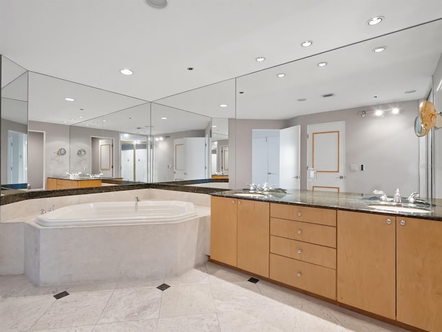 full bathroom featuring a bath, double vanity, a sink, and recessed lighting