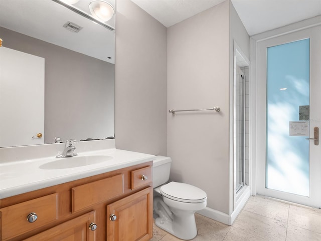 bathroom with toilet, vanity, visible vents, baseboards, and an enclosed shower