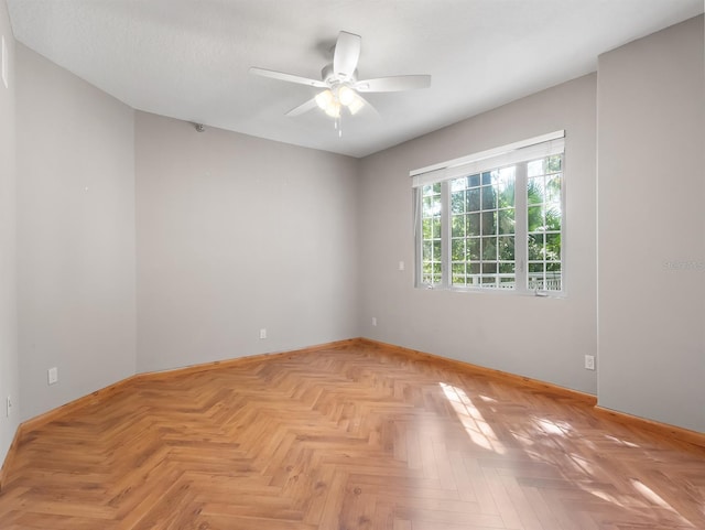 spare room featuring ceiling fan and baseboards