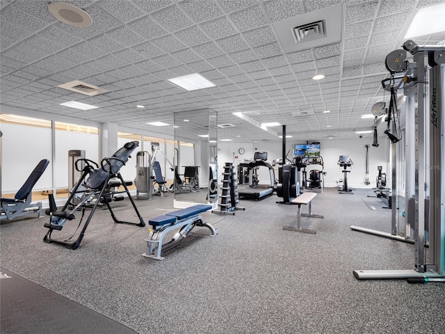 exercise room with a paneled ceiling and visible vents