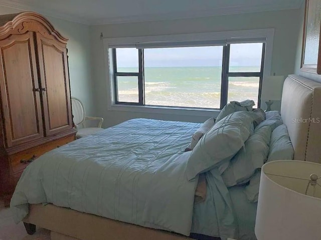 bedroom featuring a water view and crown molding