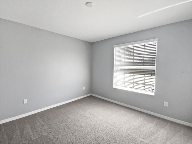 empty room with carpet floors and baseboards