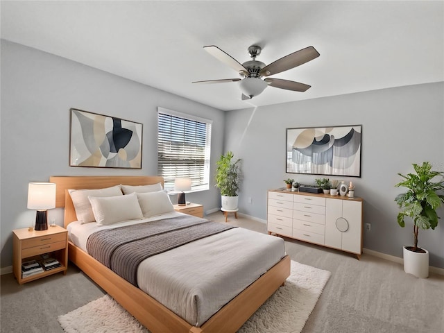 bedroom featuring ceiling fan, light carpet, and baseboards