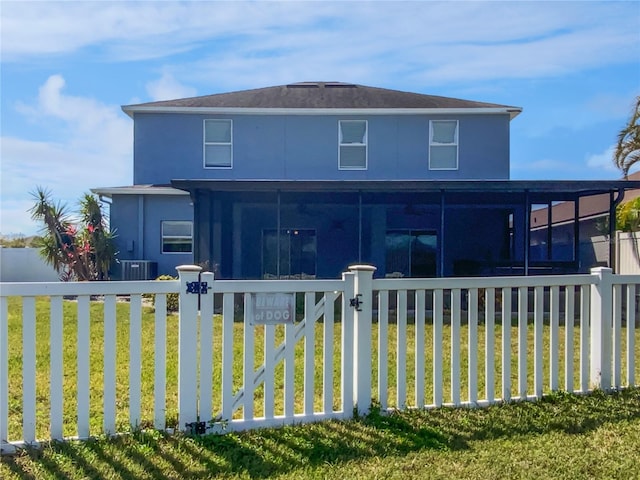 view of front of house featuring a sunroom, a fenced front yard, a gate, a front yard, and stucco siding