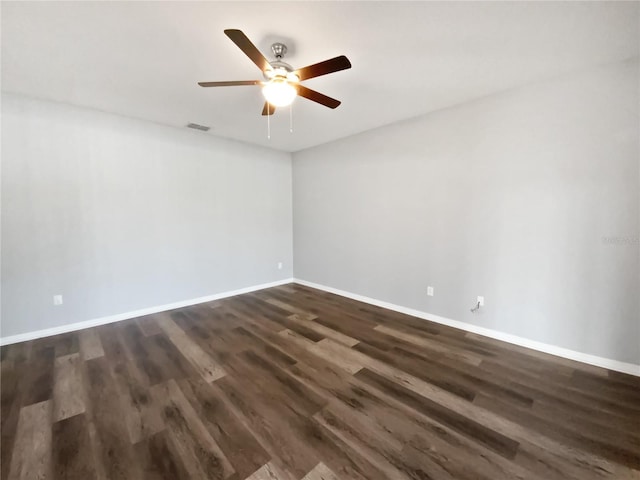 unfurnished room featuring visible vents, dark wood-type flooring, a ceiling fan, and baseboards