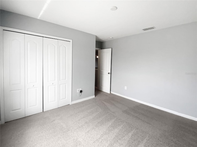 unfurnished bedroom with a closet, visible vents, baseboards, and carpet flooring