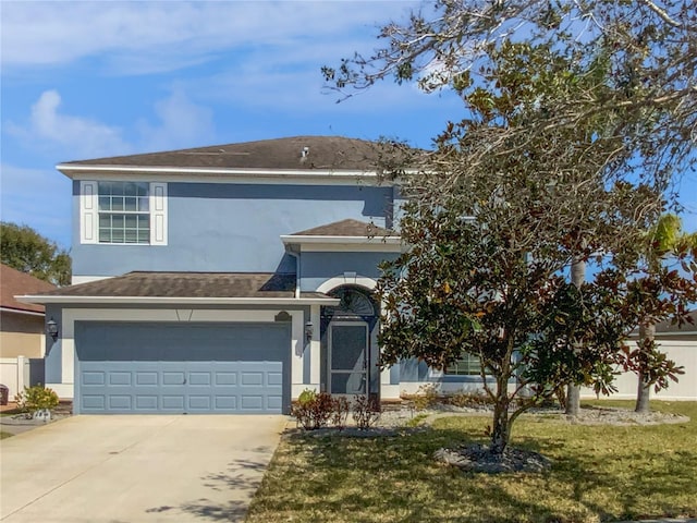 traditional home featuring a garage, driveway, a front lawn, and stucco siding