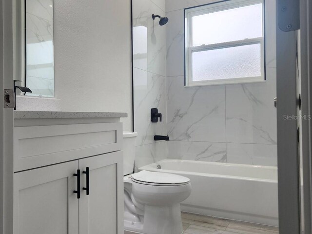 bathroom featuring toilet, shower / washtub combination, and vanity