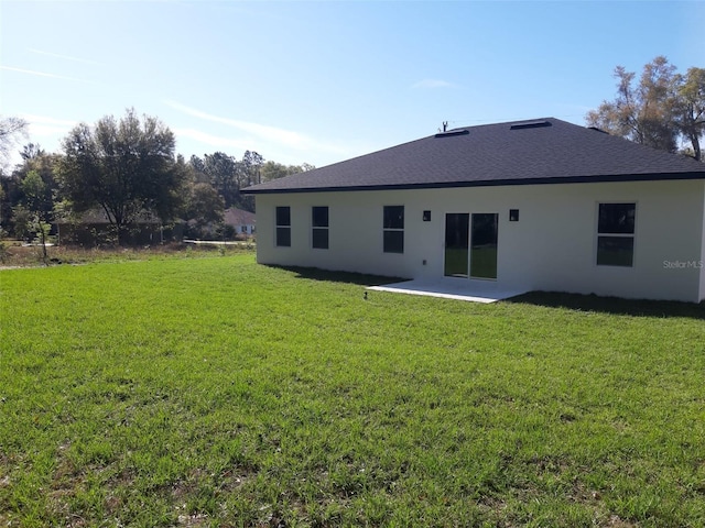 13215 SW 41st Ct, Ocala, FL 34473 - rear view of house featuring roof with shingles, a yard, stucco siding, and a patio area