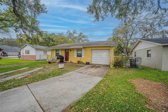 single story home with an attached garage, brick siding, fence, concrete driveway, and a front yard