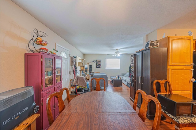 dining space with a ceiling fan and wood finished floors