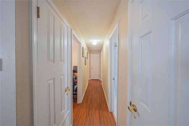 hall with baseboards and wood finished floors