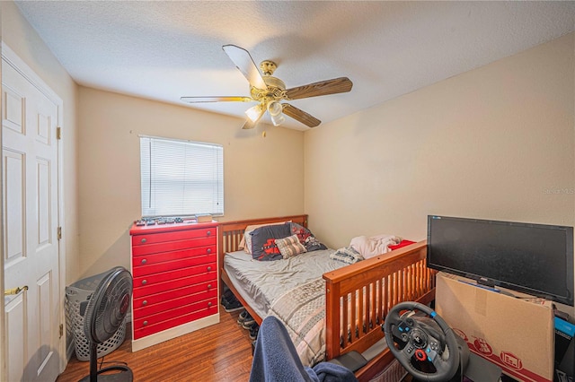 bedroom featuring a textured ceiling, a ceiling fan, and wood finished floors