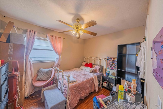 bedroom with ceiling fan, a textured ceiling, and wood finished floors