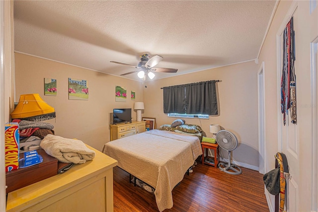 bedroom with baseboards, a textured ceiling, a ceiling fan, and dark wood-style flooring