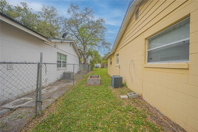 view of yard featuring cooling unit, a garden, and fence