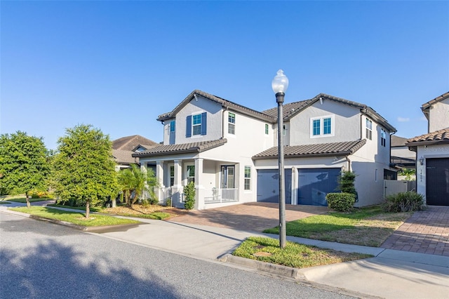 view of front of property featuring a garage, covered porch, decorative driveway, and stucco siding