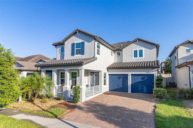 view of front of home featuring an attached garage, covered porch, decorative driveway, and stucco siding