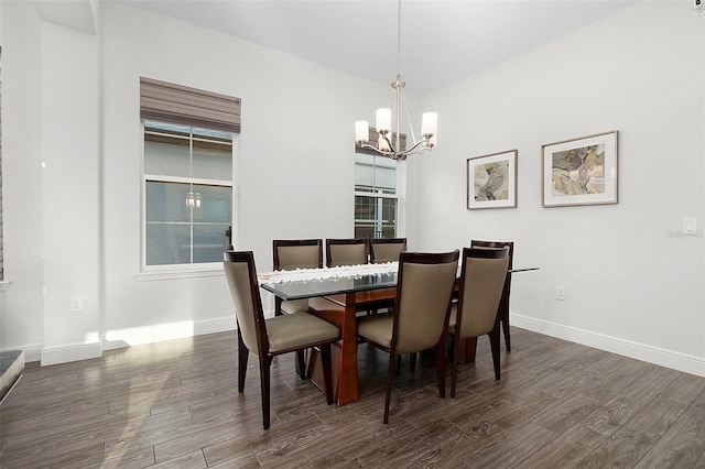 dining space featuring baseboards, dark wood finished floors, and a notable chandelier