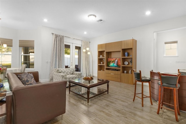 living room with a chandelier, recessed lighting, visible vents, light wood-style floors, and french doors