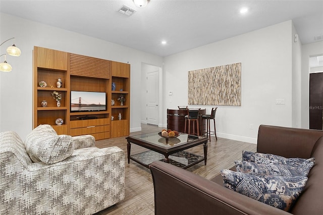 living area featuring recessed lighting, wood finished floors, visible vents, and baseboards