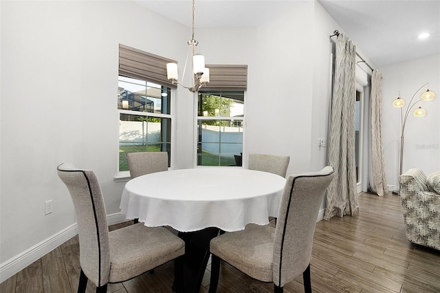 dining space with baseboards, a chandelier, wood finished floors, and recessed lighting