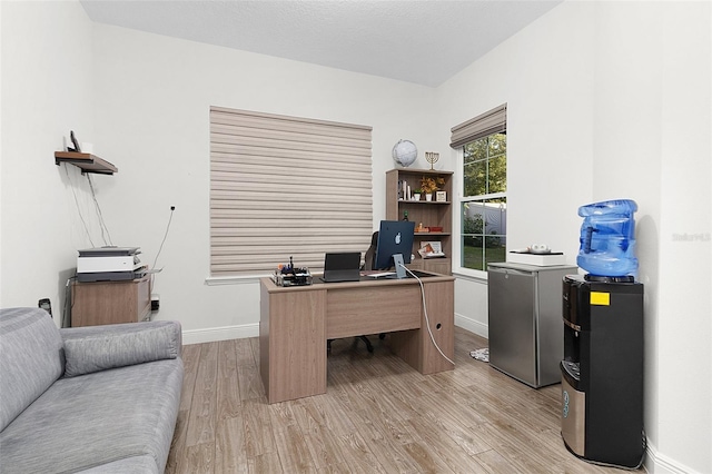 office space with light wood-style flooring and baseboards