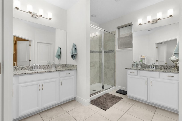 full bath featuring tile patterned floors, a sink, and a shower stall