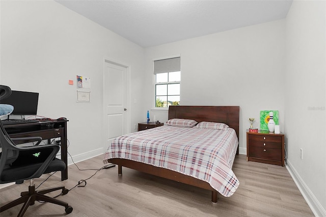 bedroom featuring light wood-style flooring and baseboards