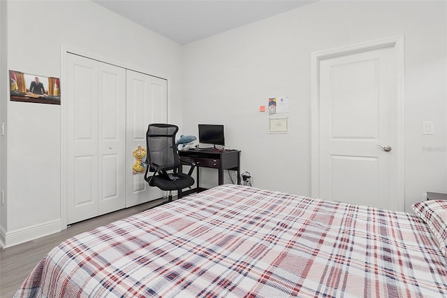 bedroom featuring a closet, baseboards, and wood finished floors