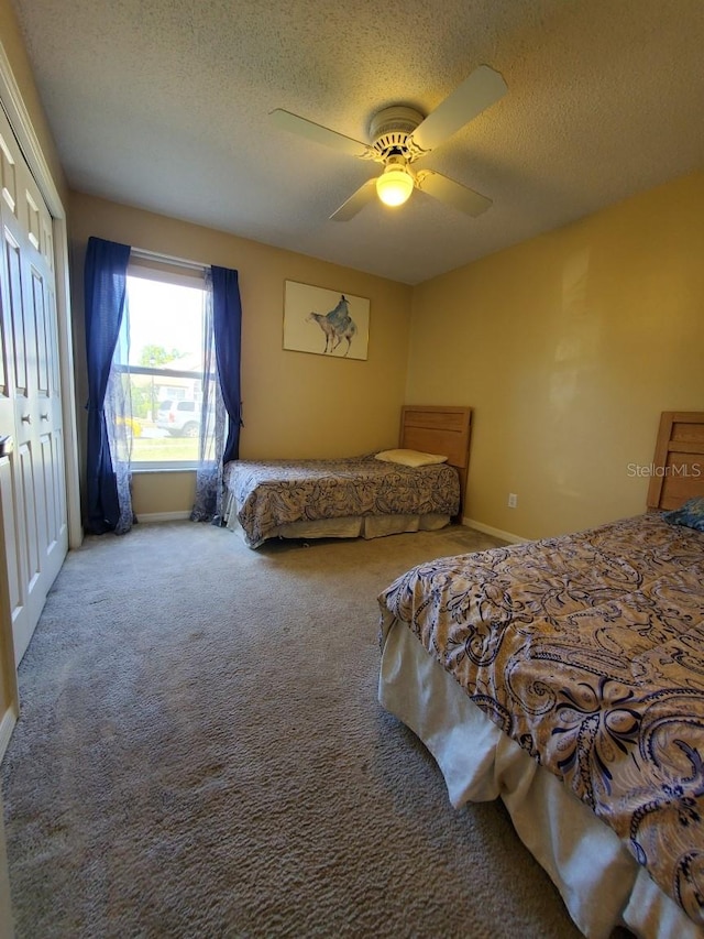 bedroom with carpet floors, a closet, a ceiling fan, a textured ceiling, and baseboards