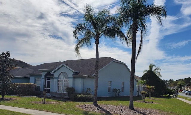 ranch-style house with a front lawn and stucco siding