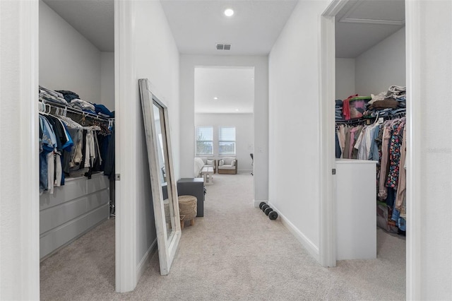 corridor featuring visible vents, baseboards, and carpet floors