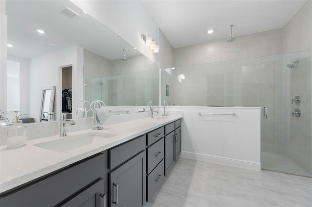 full bath with double vanity, visible vents, a stall shower, and a sink