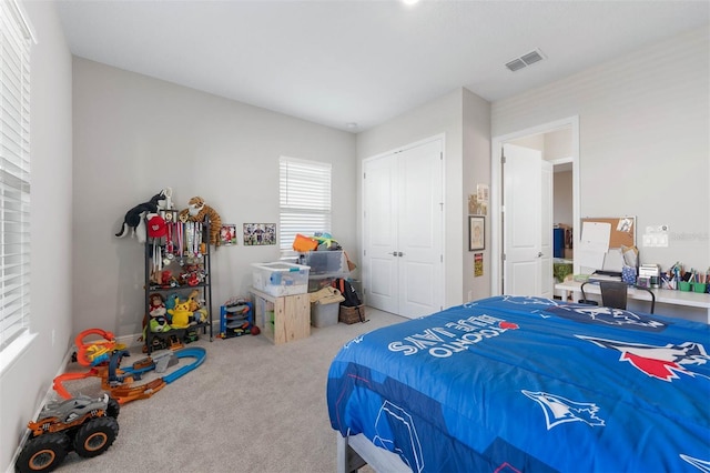 carpeted bedroom featuring visible vents and a closet