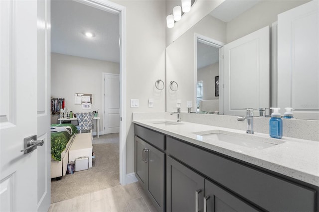 full bathroom with a sink, baseboards, and double vanity