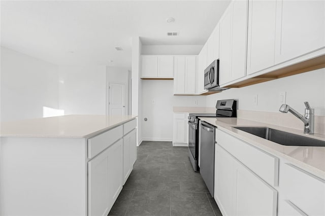 kitchen with visible vents, white cabinets, appliances with stainless steel finishes, light countertops, and a sink