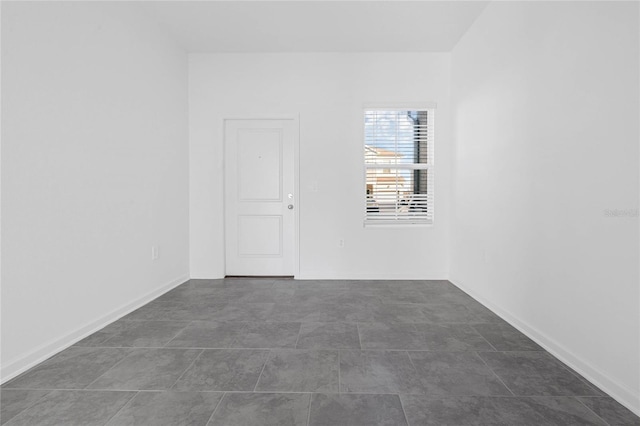 unfurnished room with baseboards