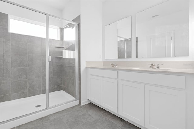 full bath featuring visible vents, a sink, a shower stall, and double vanity