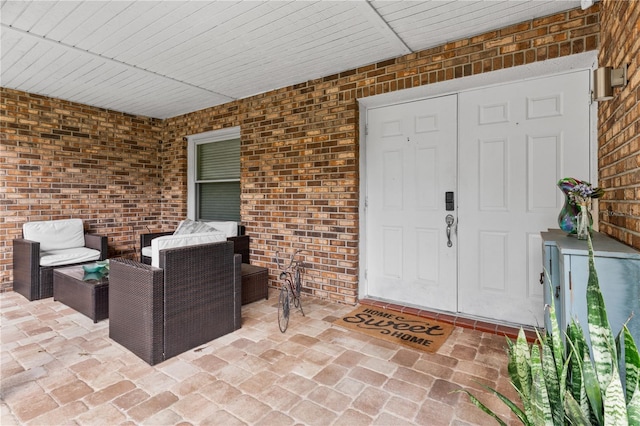 entrance to property featuring a patio area and brick siding