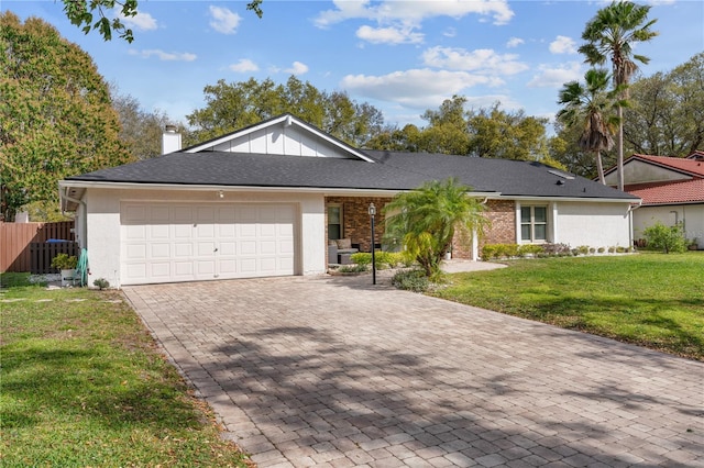 ranch-style house featuring a garage, fence, decorative driveway, a chimney, and a front yard